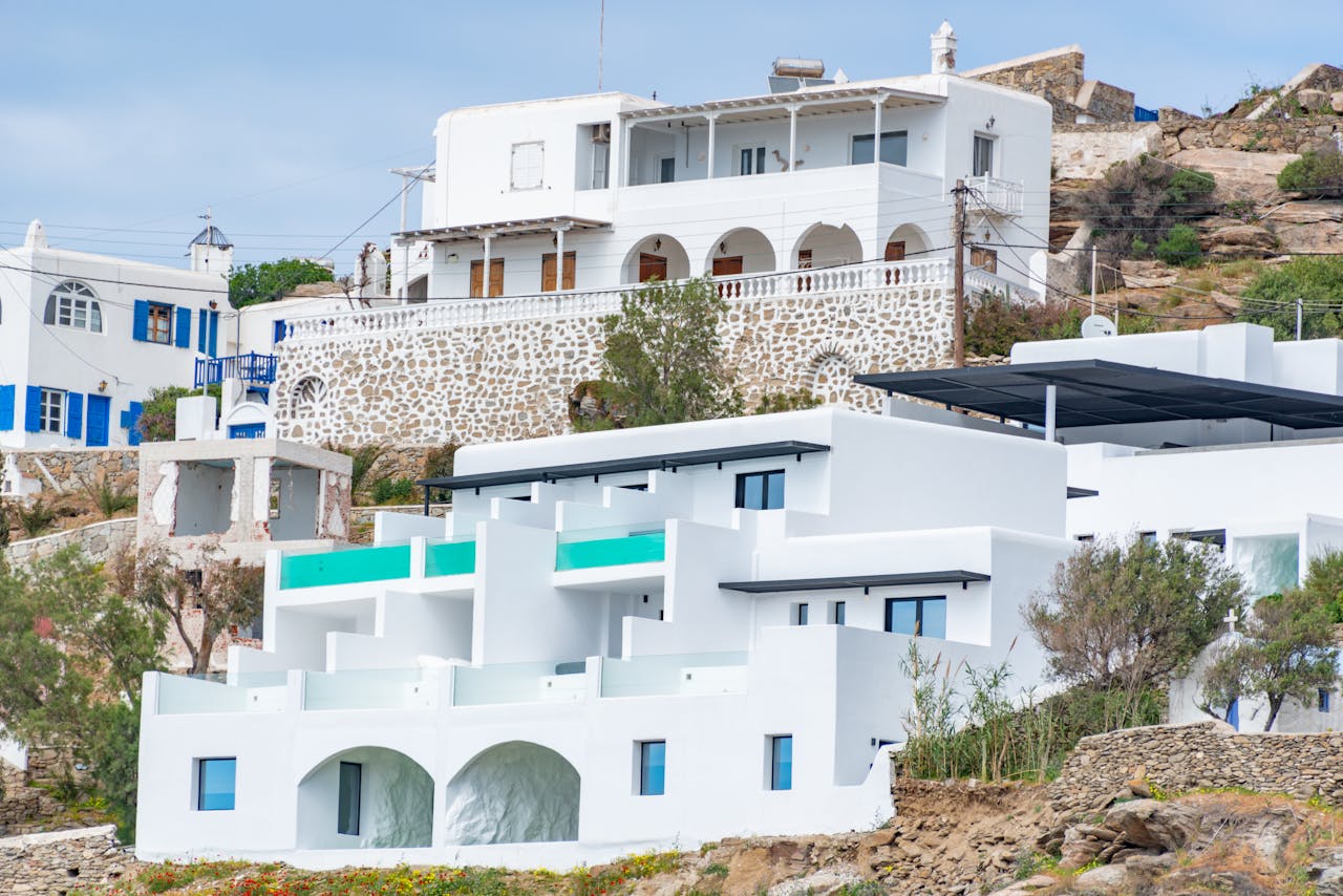 services-04 Whitewashed buildings on a Greek island showcasing traditional architecture with sea views.