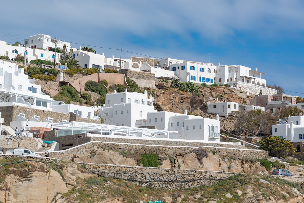services-01 Scenic view of iconic white houses on a Greek hillside, showcasing traditional architecture.